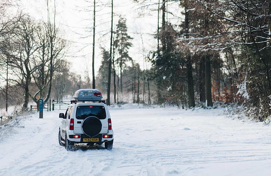 Auto met dakkoffer in de sneeuw