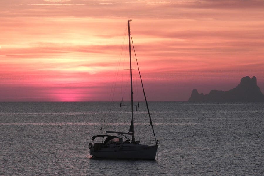 Zeilboot in ee baai op Formentera tijdens zonsondergang