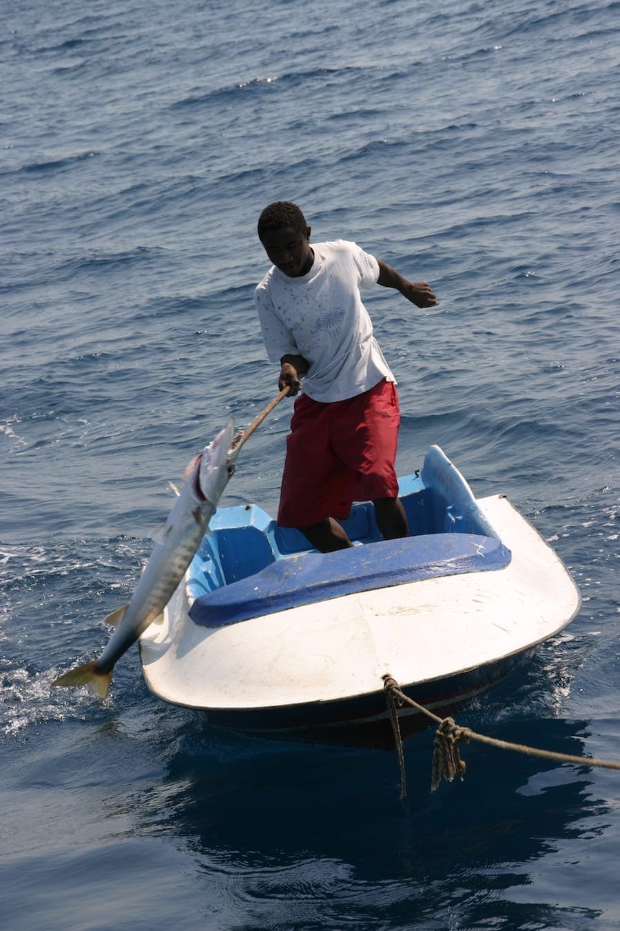 Visser haalt de vangst binnen op zee bij Madagaskar