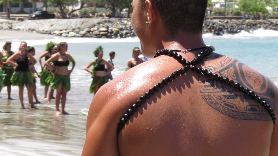 Vrouwen en mannen in traditionele kledij voor de haka dans