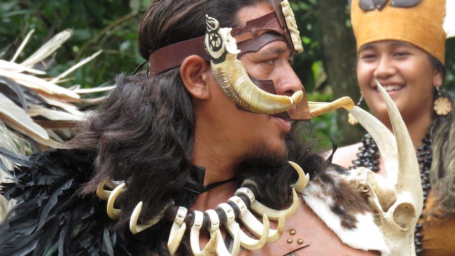 Polynesische man in traditionele kledij tijdens de haka dans