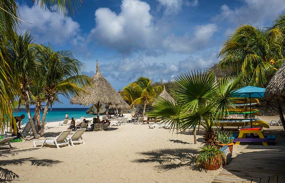 Strand met palbomen en ligbedden op Curacao