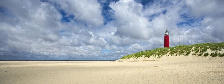 Breed strand met vuurtoren in de duinen op Texel