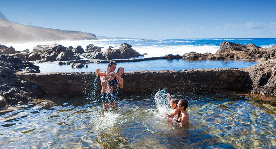 Kinderen spelen in een natuurlijk zwembad bij Garachico