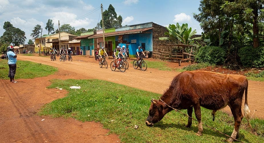 Deelnemers aan de fietstour in Kenia passeren een dorpje