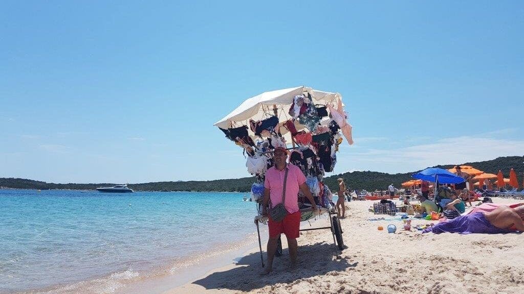 Verkoper op strand verkoopt zijn spullen