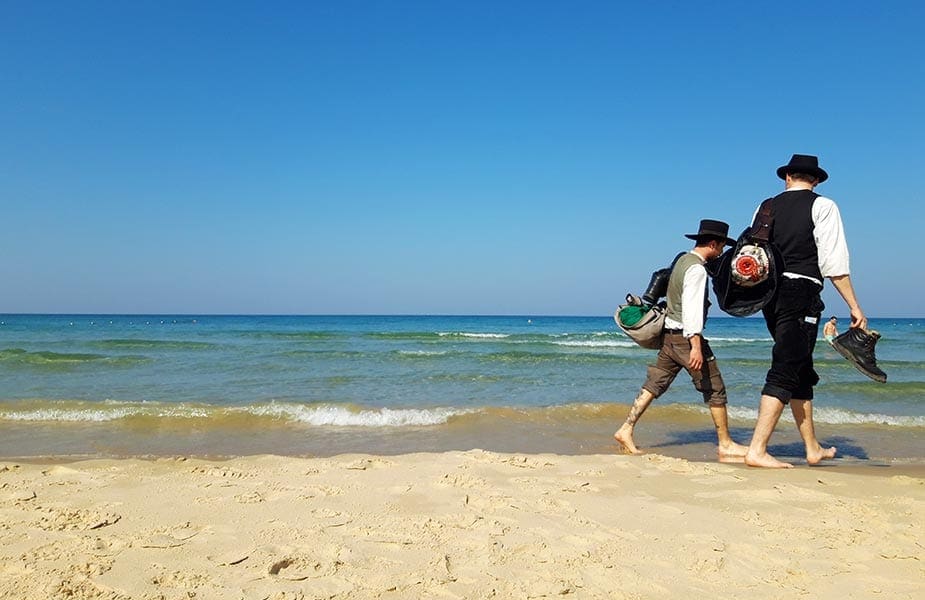 Mannen lopen op strand in Israel