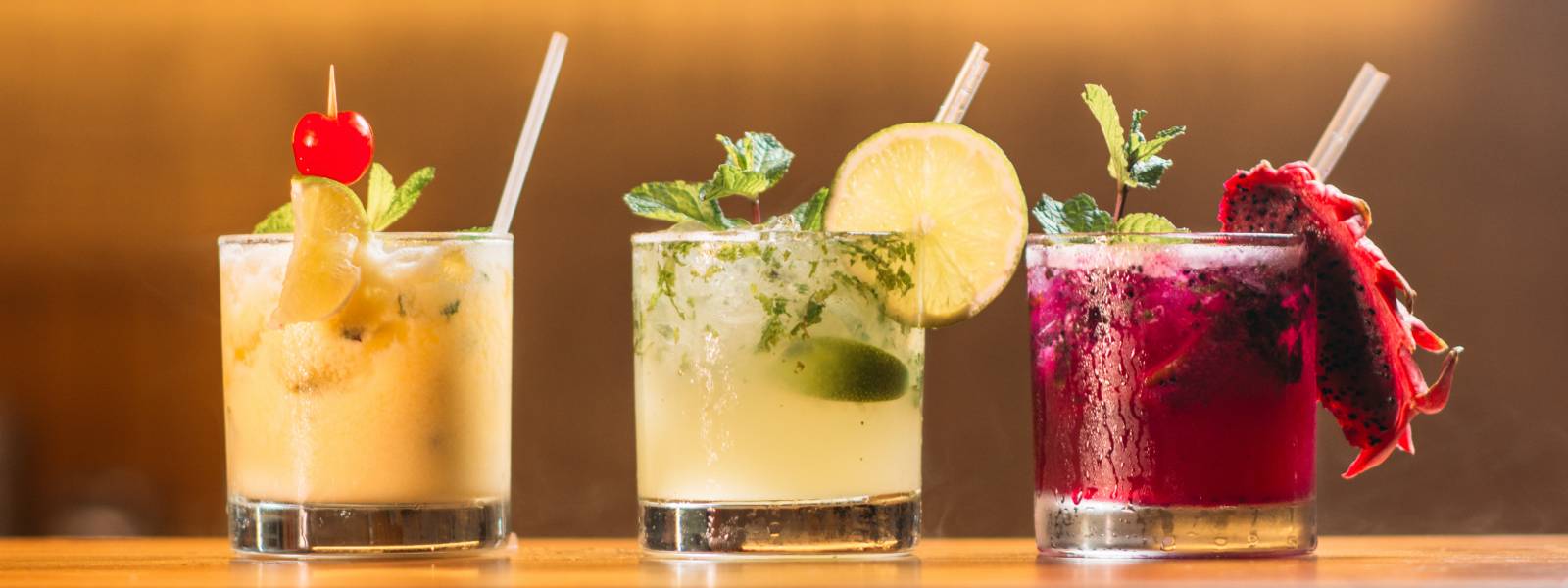 Drie kleurrijke cocktails op een rij