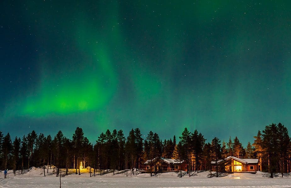 Het noorderlicht boven hutjes in Lapland