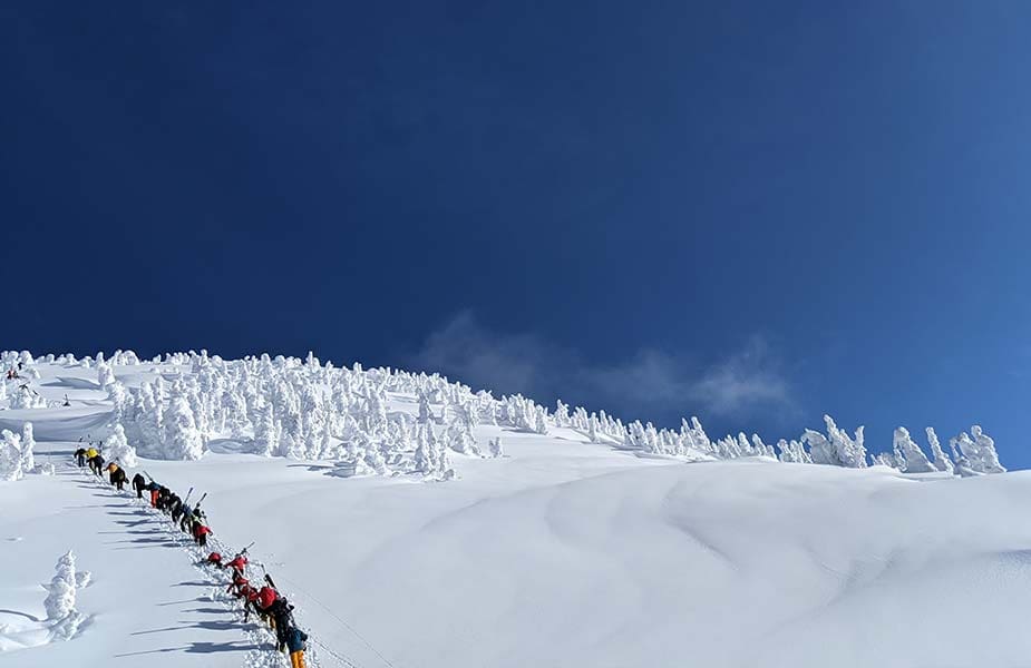 Skiers die naar de top van de piste lopen