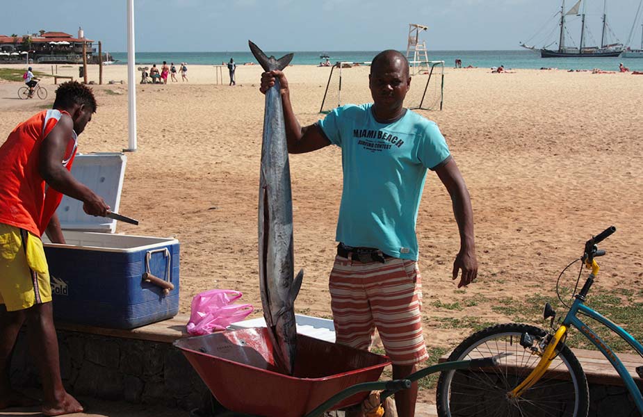 Visser met een vis bij het strand van Palmeira op Kaapverdie