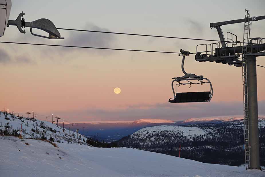 Maan en zon tijdens skiën in Scandinavië