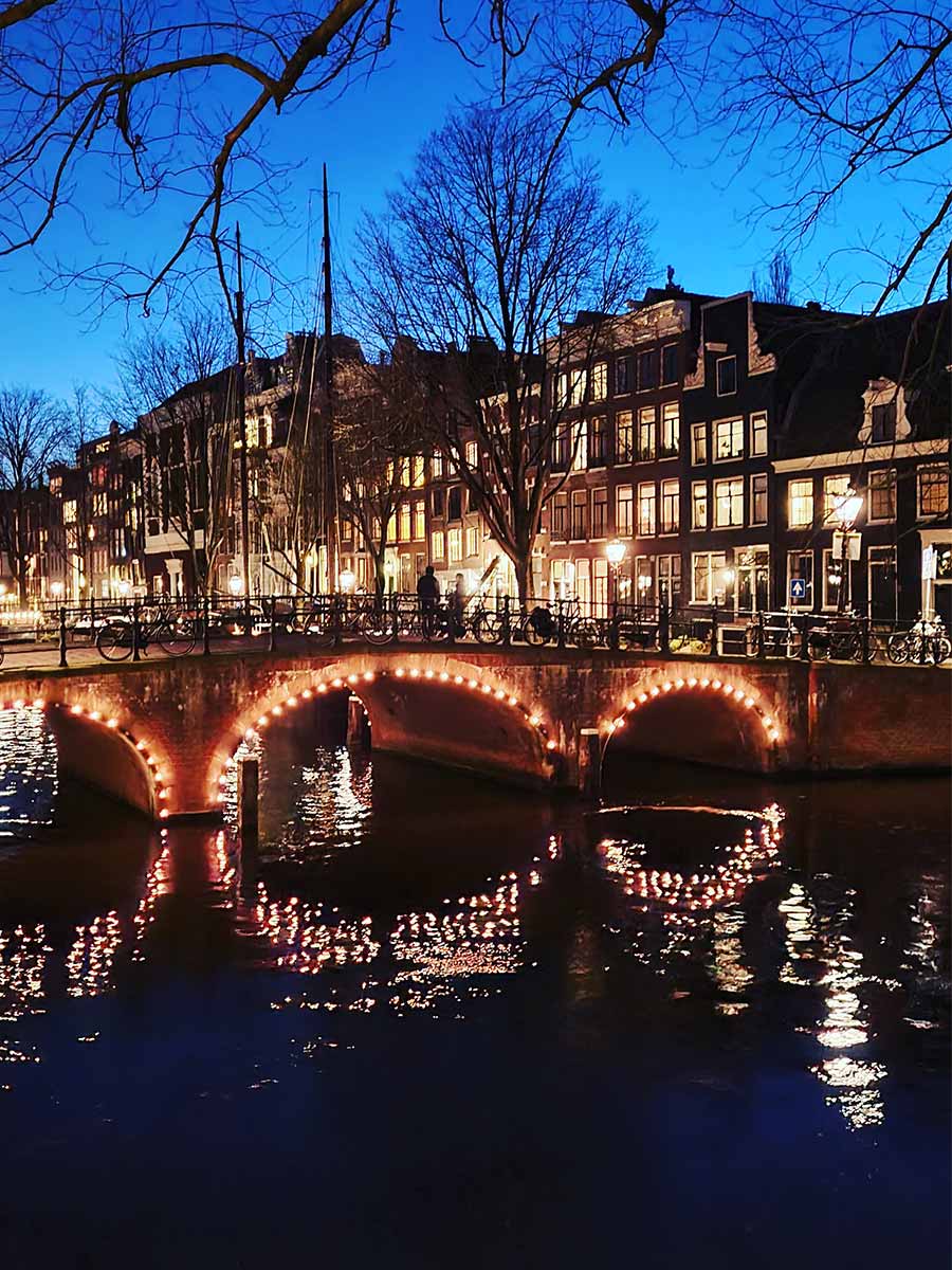 Een verlichte brug in de grachten van Amsterdam