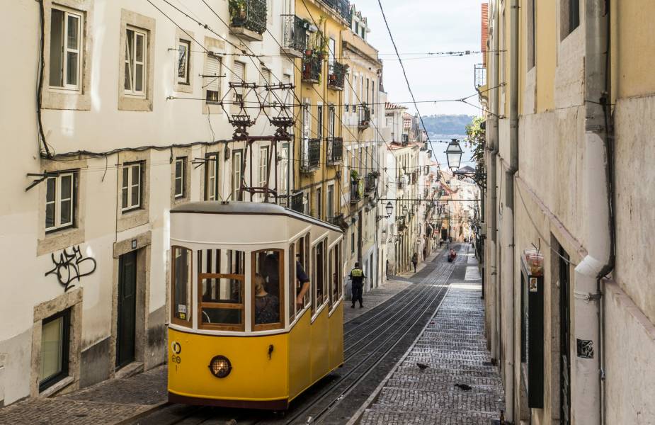 Gele tram door smalle straten in Lissabon