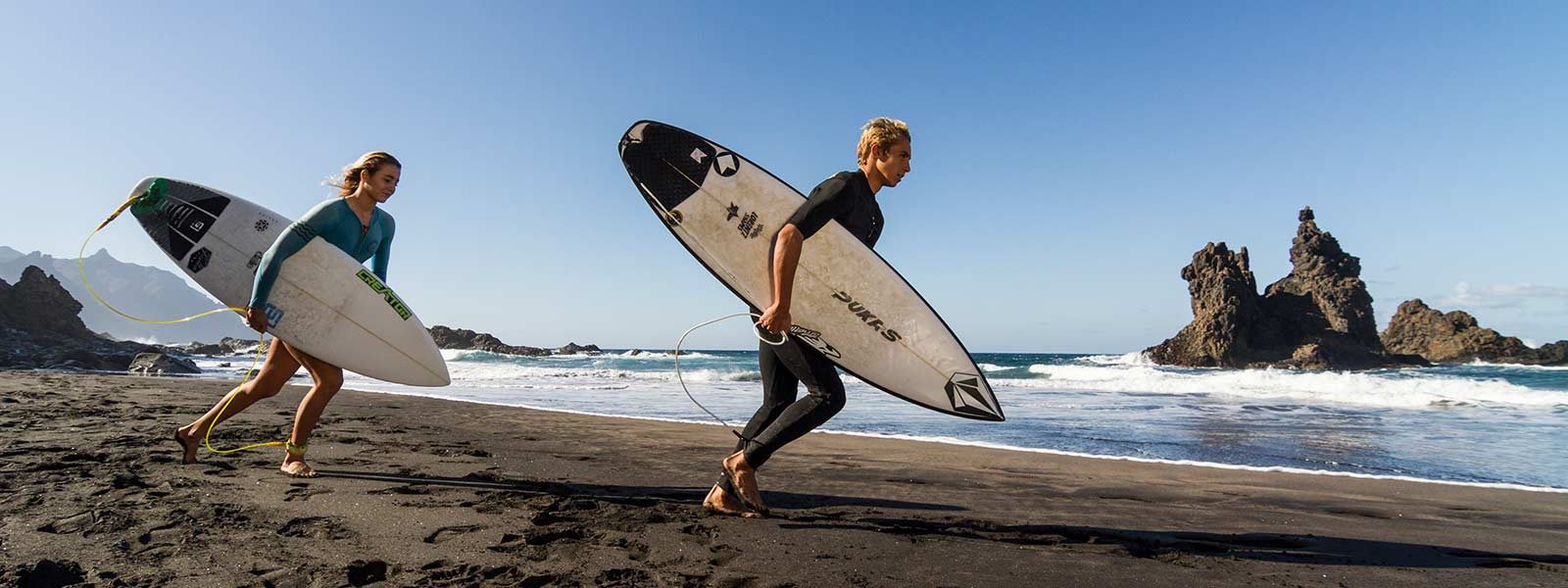 Surfers met surfboard gaan de zee in op Tenerife